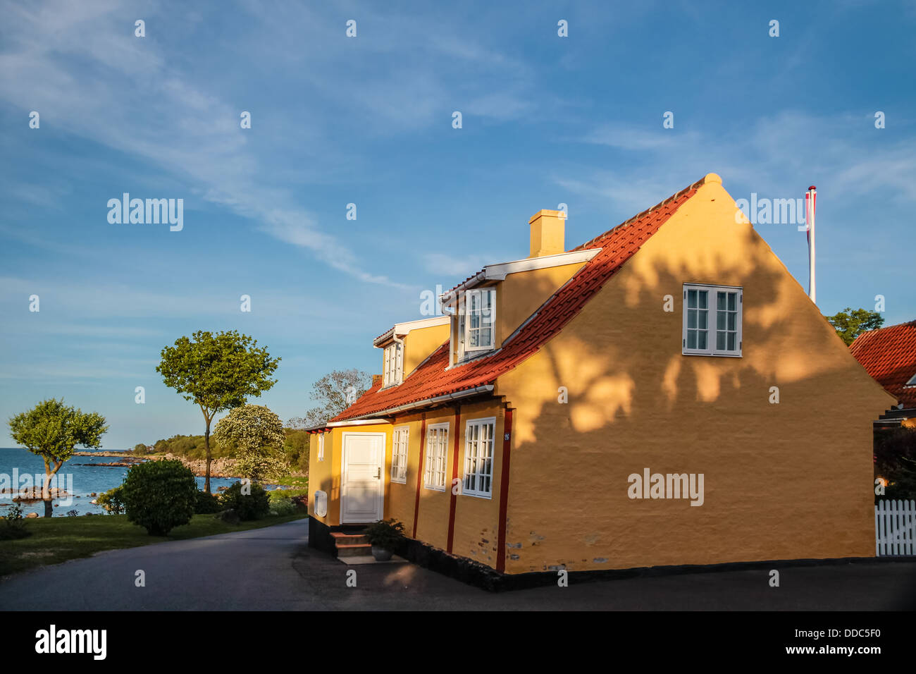 Gelbe Haus im Abendlicht in dem kleinen Dorf gelistet auf Bornholm, Dänemark Stockfoto