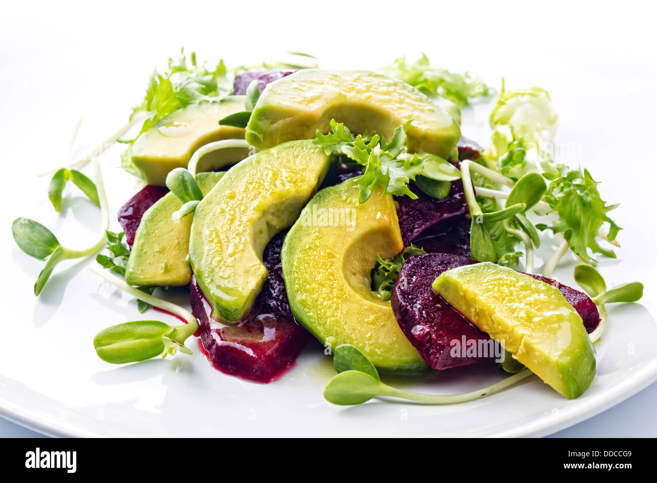 Rote Beete und Avocado-Salat mit Zitrone und frischen Sonnenblumen-Sprossen Stockfoto