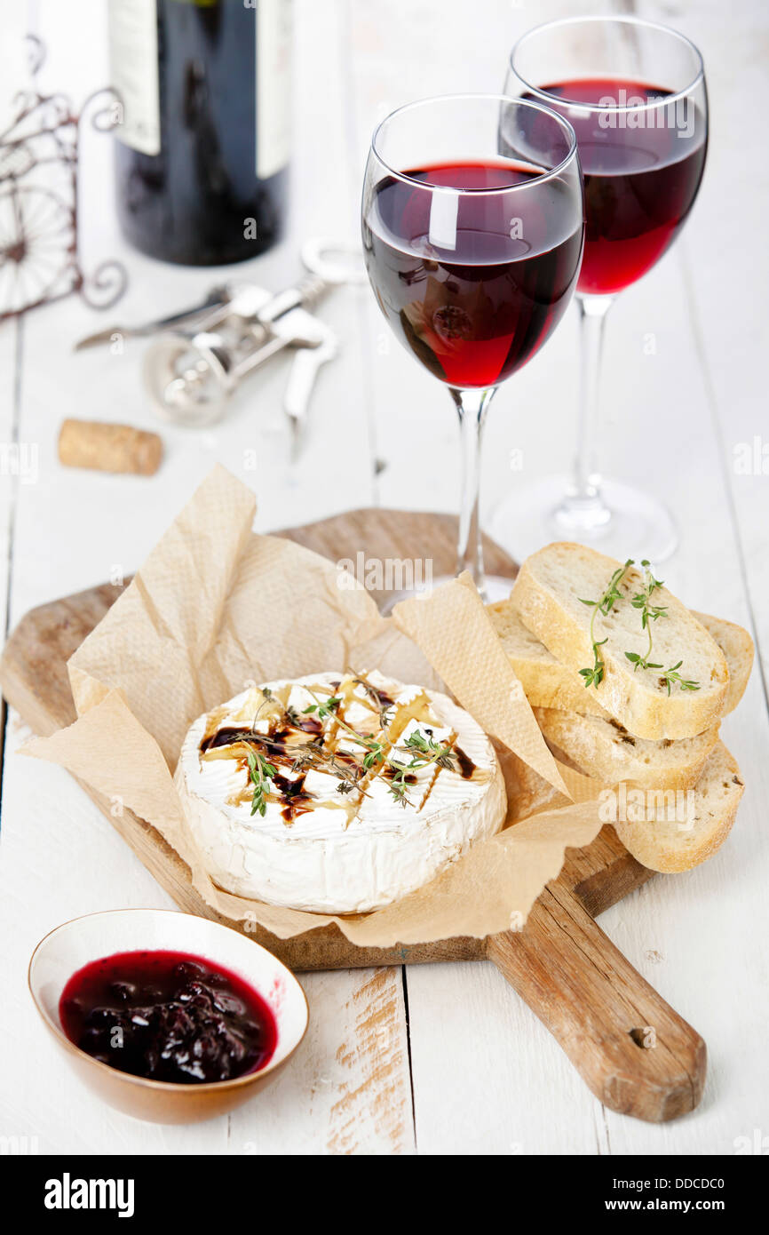 Gebackener Camembert Käse mit Rotwein und geröstetem Brot auf Holzbrett Stockfoto
