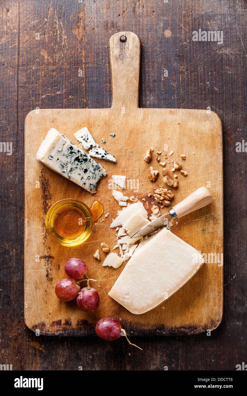 Käse mit Honig, Nüssen und Trauben auf hölzernen Cutting Board Stockfoto