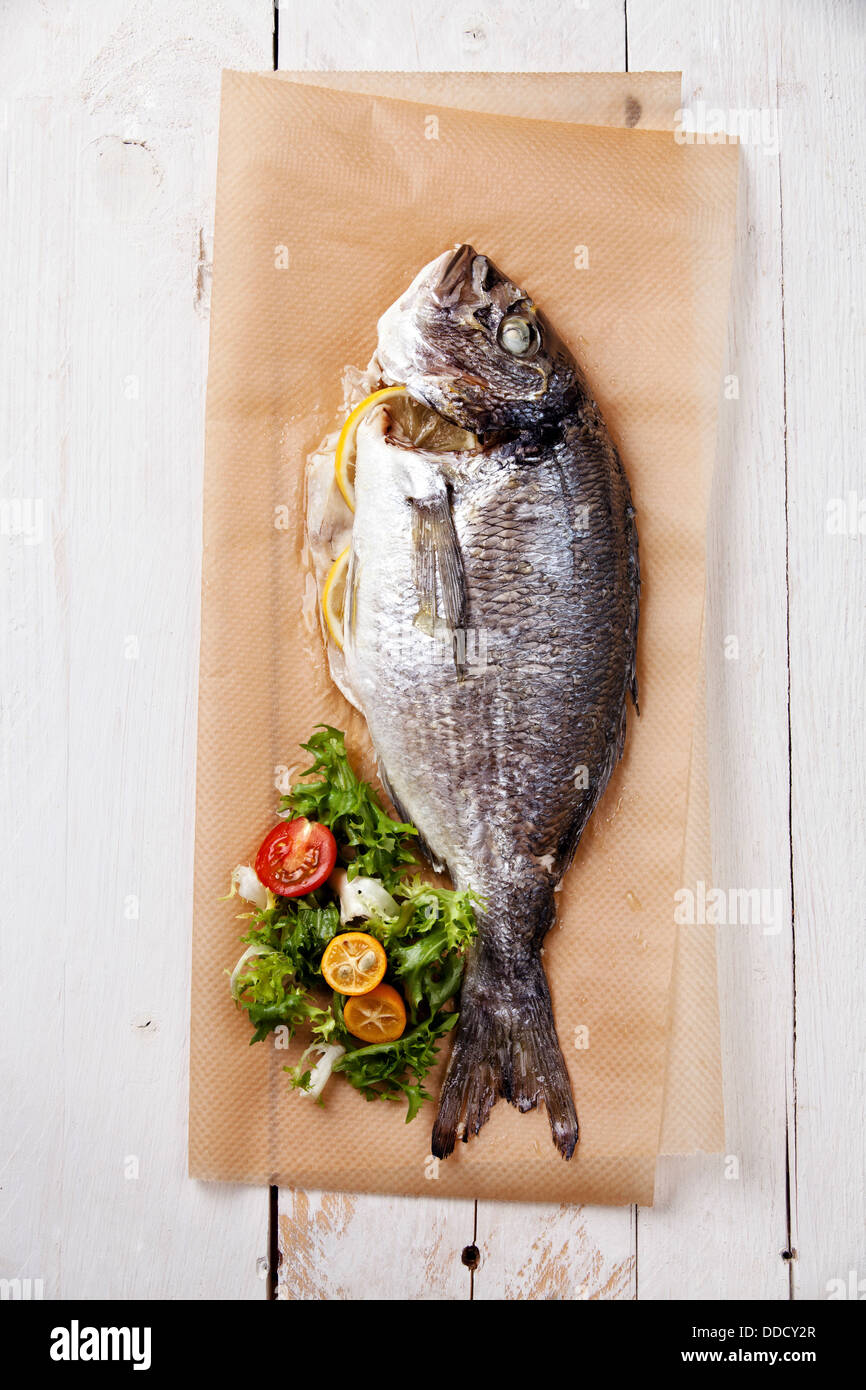 Gebackener Fisch mit Zitrone und Salat Stockfoto