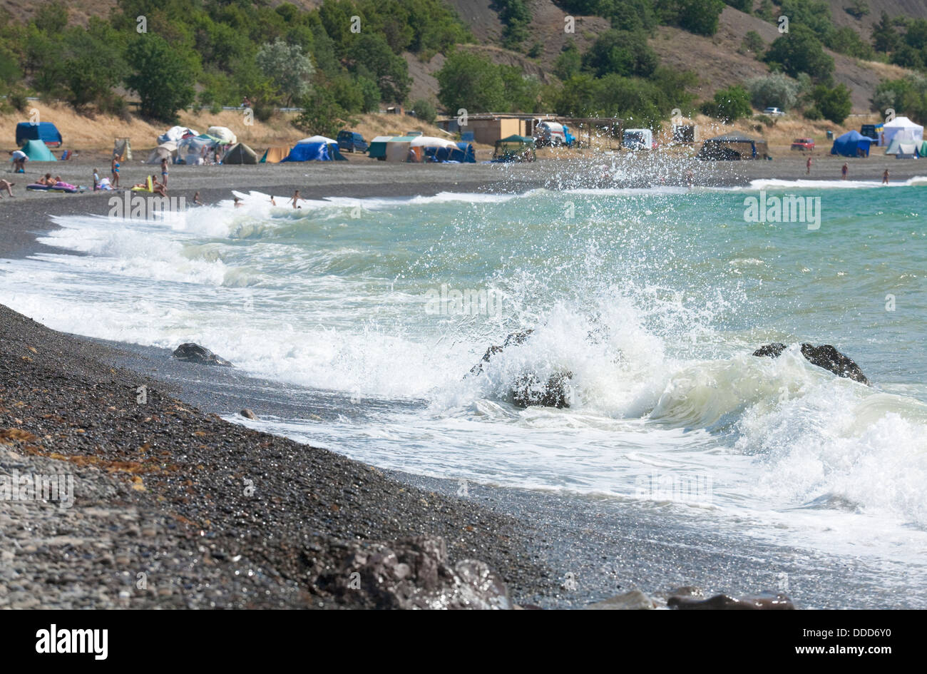 Meer Surfwelle brechen auf Küste und Zelte am Strand (Krim, Ukraine) Stockfoto