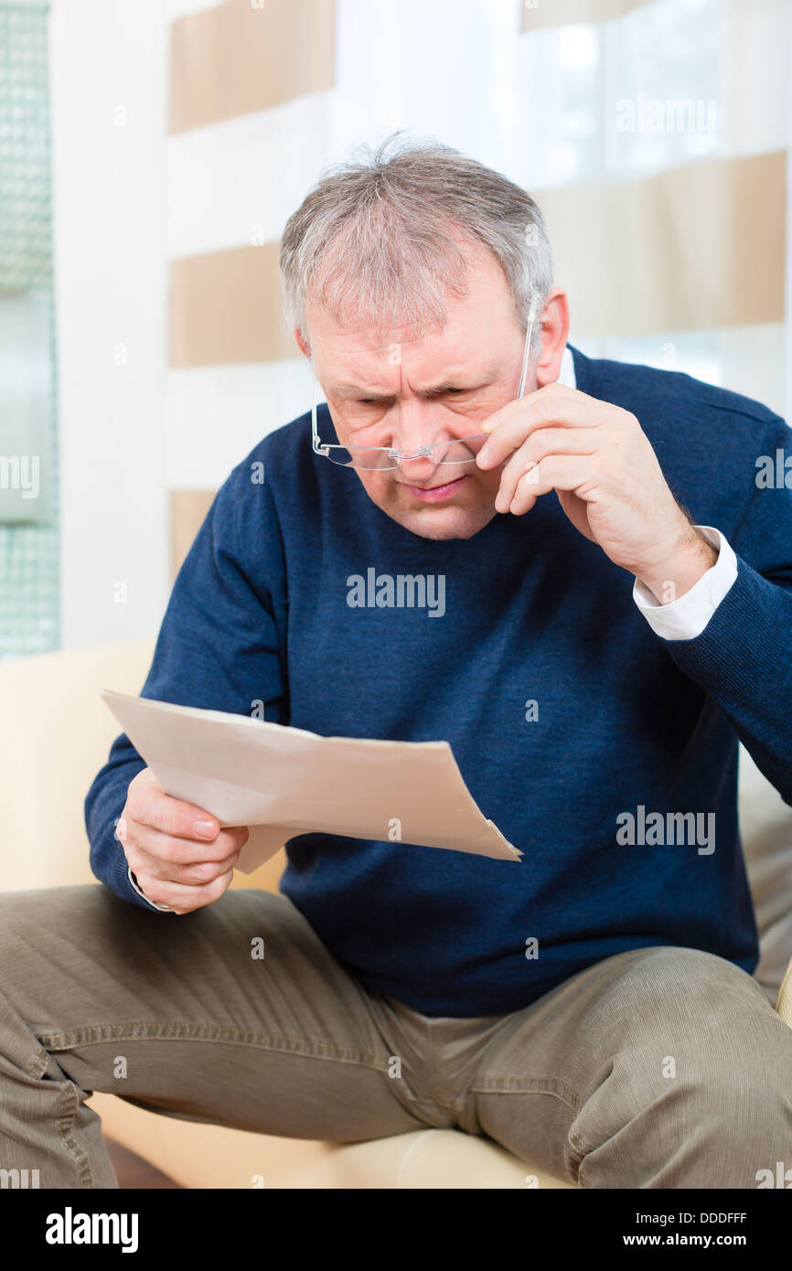 Ältere Menschen oder Senior einen Brief erhalten haben, vielleicht ist es eine Erinnerung oder eine Rechnung Stockfoto