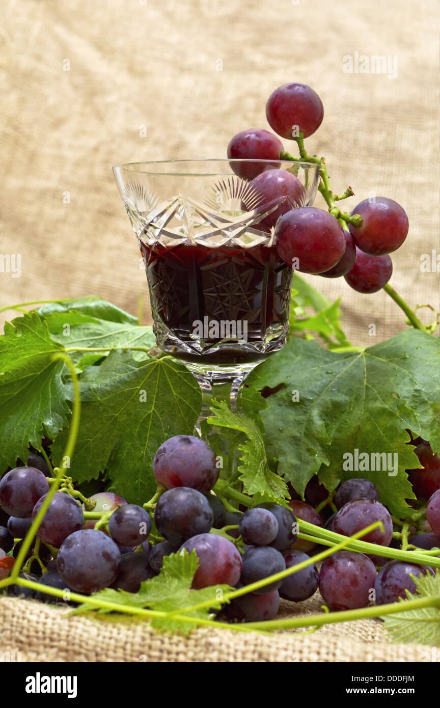 Rotwein im Weinglas mit süßen Trauben. Selektiven Fokus mit geringen Schärfentiefe. Stockfoto