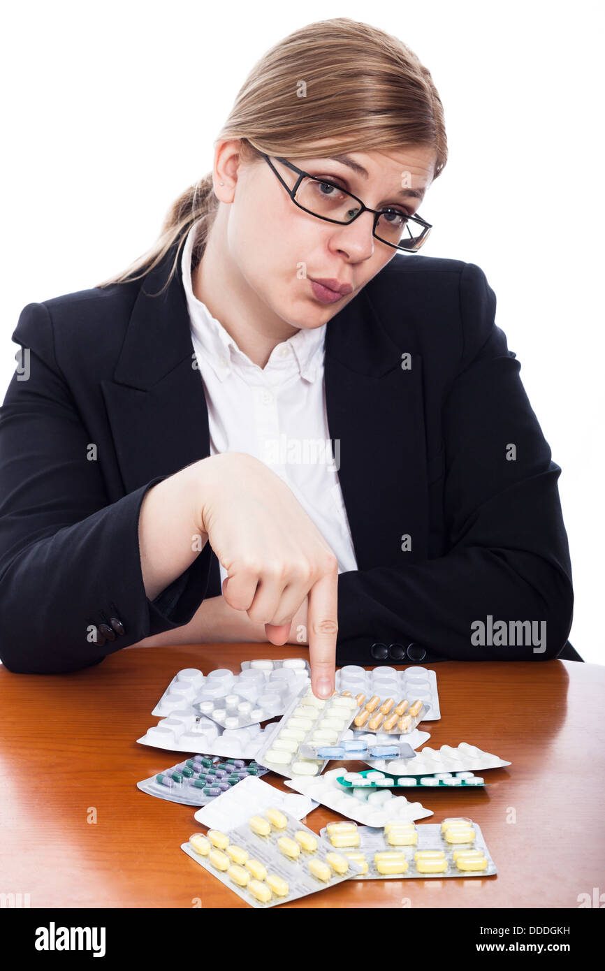 Business-Frau zeigt auf Pillen, isoliert auf weißem Hintergrund. Stockfoto