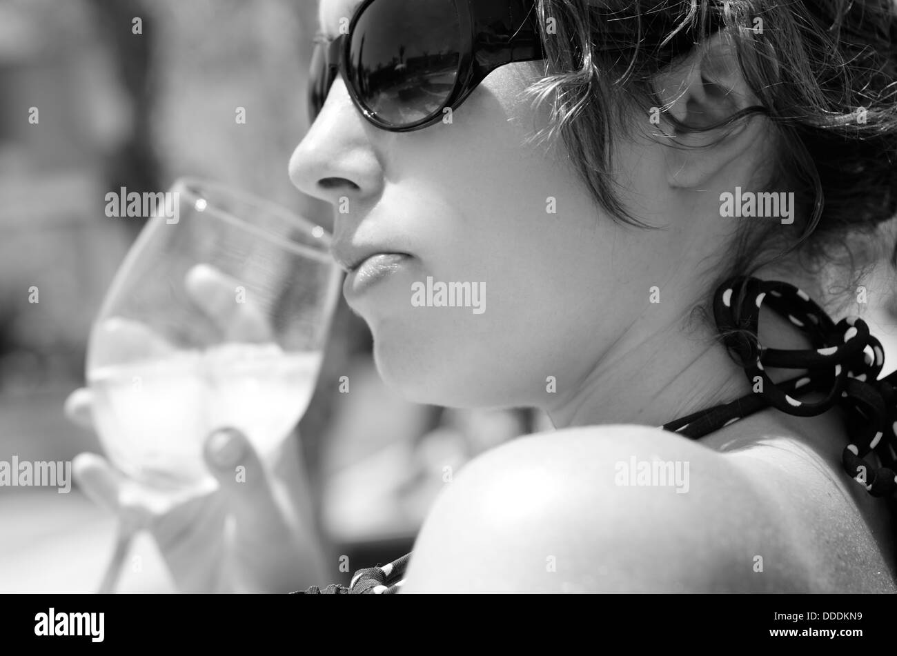 Junge Frau hautnah in schwarz / weiß aus einem Glas Wein zu trinken Stockfoto