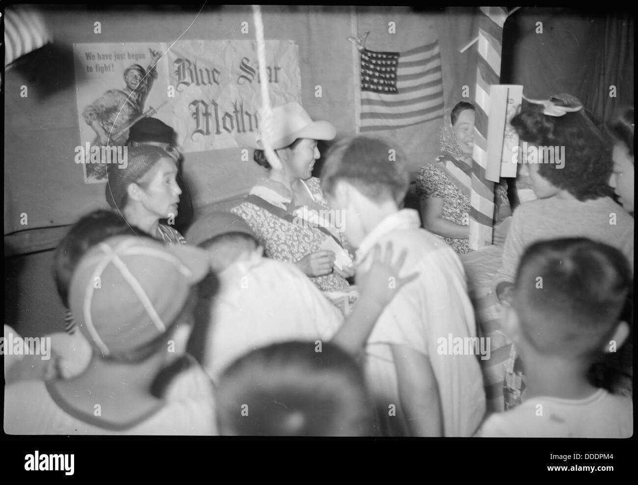 Nächtliche Karnevalsaufnahmen im Granada Relocation Center in Amache, Colorado, bei denen Internierte an Freizeitaktivitäten teilnehmen. Die Bilder spiegeln Momente der Erleichterung und Ablenkung inmitten der Internierungserfahrung während des Zweiten Weltkriegs wider Stockfoto
