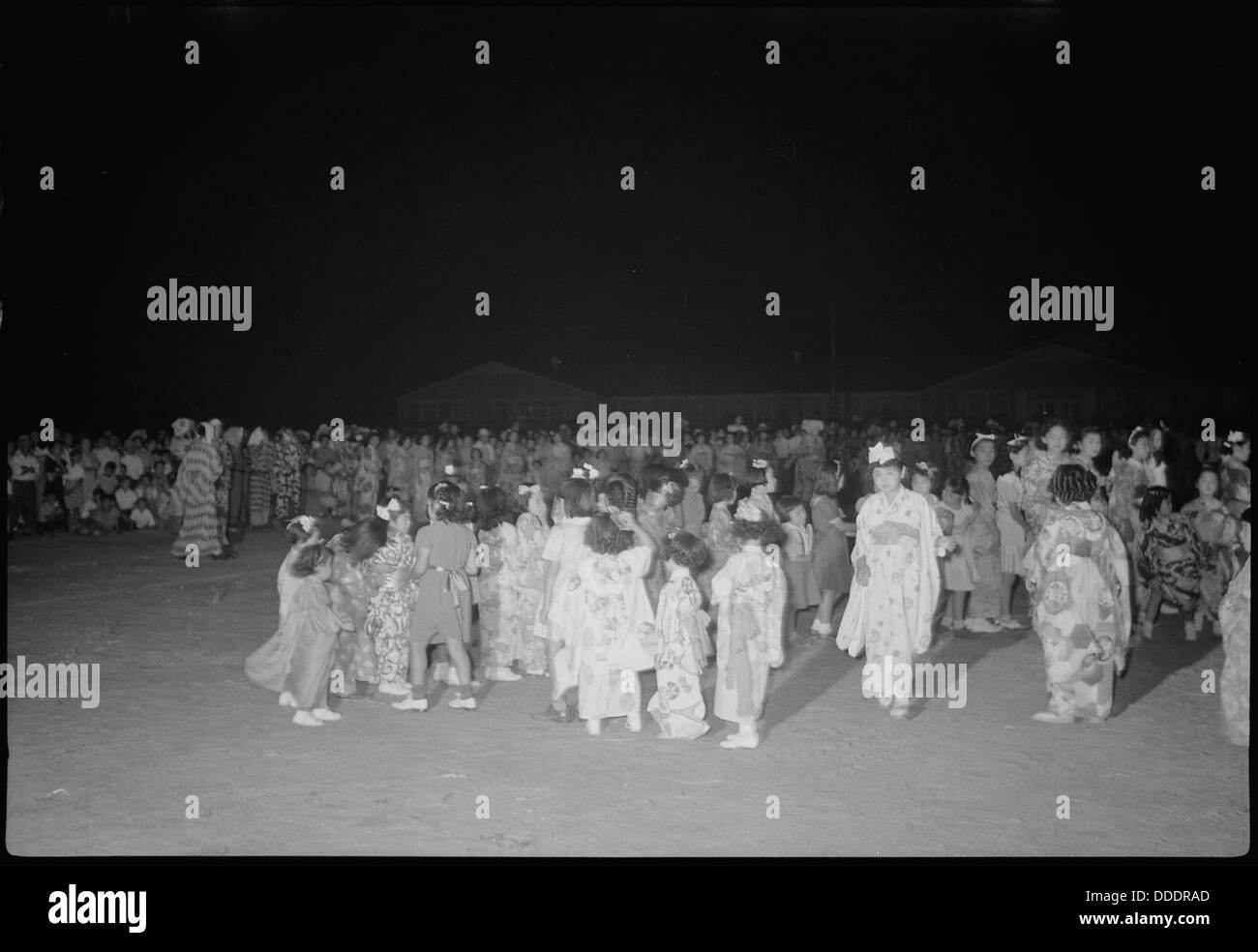 Im Granada Relocation Center (Amache) warten junge Tänzer während der Pause auf Erfrischungen, die Momente der Normalität innerhalb des Internierungslagers darstellen. Stockfoto
