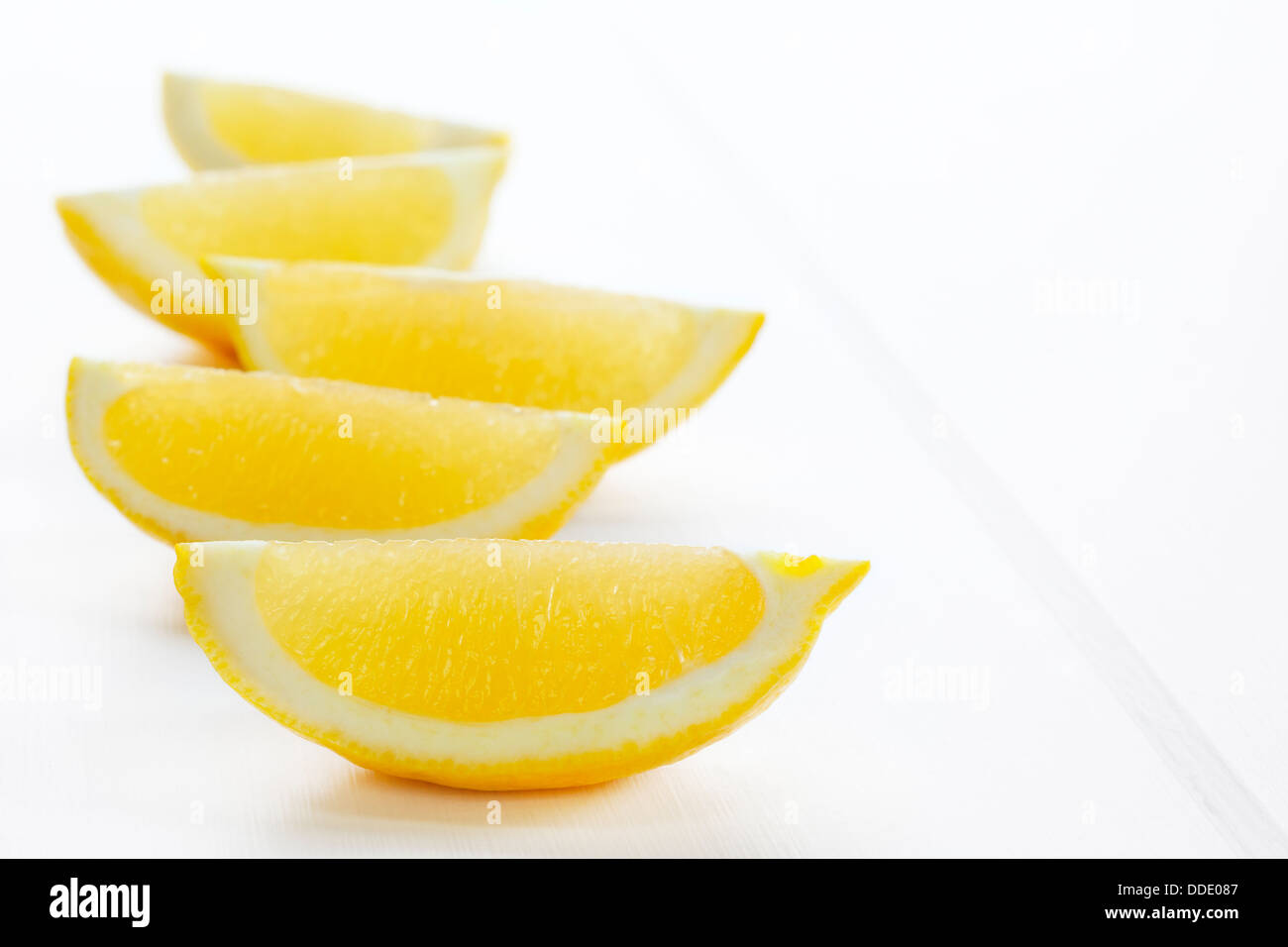 Zitrone Keile oder Scheiben auf einem weißen Hintergrund mit weichen Schatten. Stockfoto