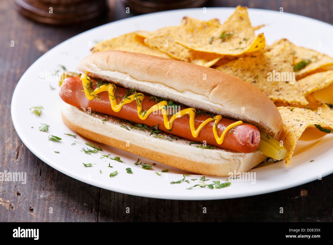 Hot Dog mit Senf und Kartoffel-Chips auf hölzernen Hintergrund Stockfoto