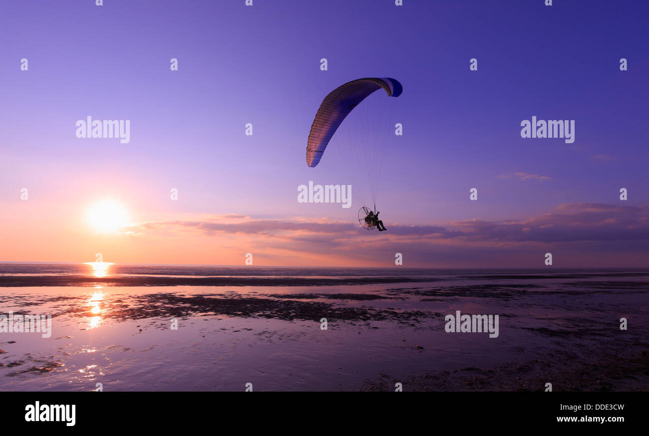 Mann in ein powered Paraglider über Heacham Buche mit Sonnenuntergang über The Wash. Stockfoto