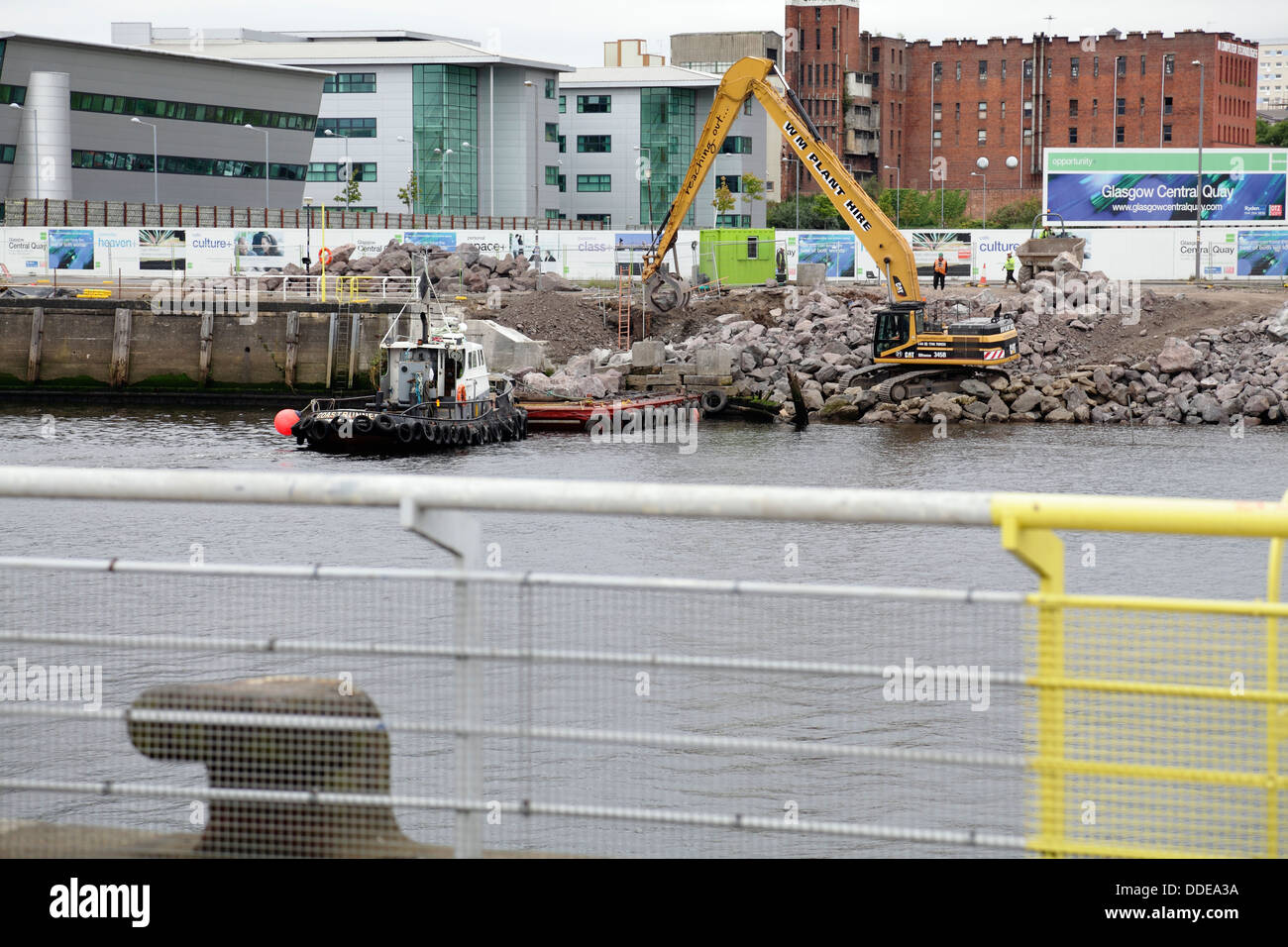 Im Gange sind Arbeiten zur Reparatur des eingestürzten Gehwegs am Anderston Quay am Fluss Clyde mit einem Bagger, Schlepper und einem Lastkahn in Glasgow, Schottland, Großbritannien Stockfoto