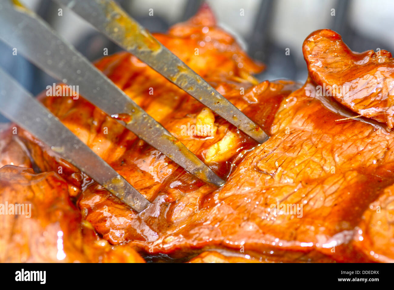 Makroaufnahme von ein Stück Steak auf dem Grill mit einer Gabel Stockfoto