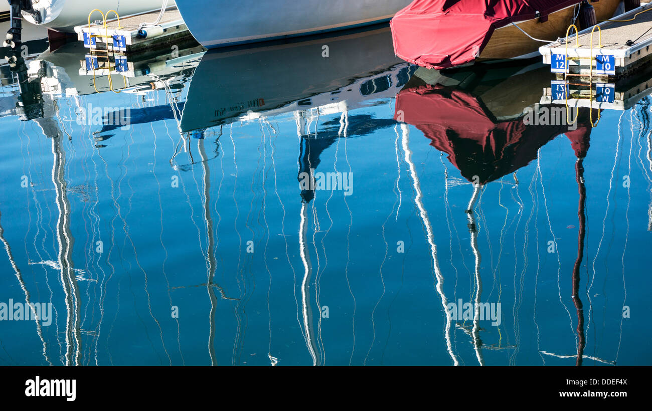 vertäut Segelboote Mischung mit schönen wässrig Bildern von Bootsrümpfen & schwankende Masten gegen blauen Himmel Edmonds Yachthafen Hafen Stockfoto