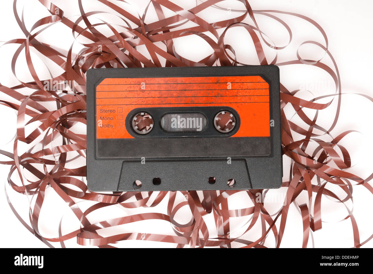Retro-Audio-Kassette mit herausgezogen Band auf weißem Hintergrund Stockfoto
