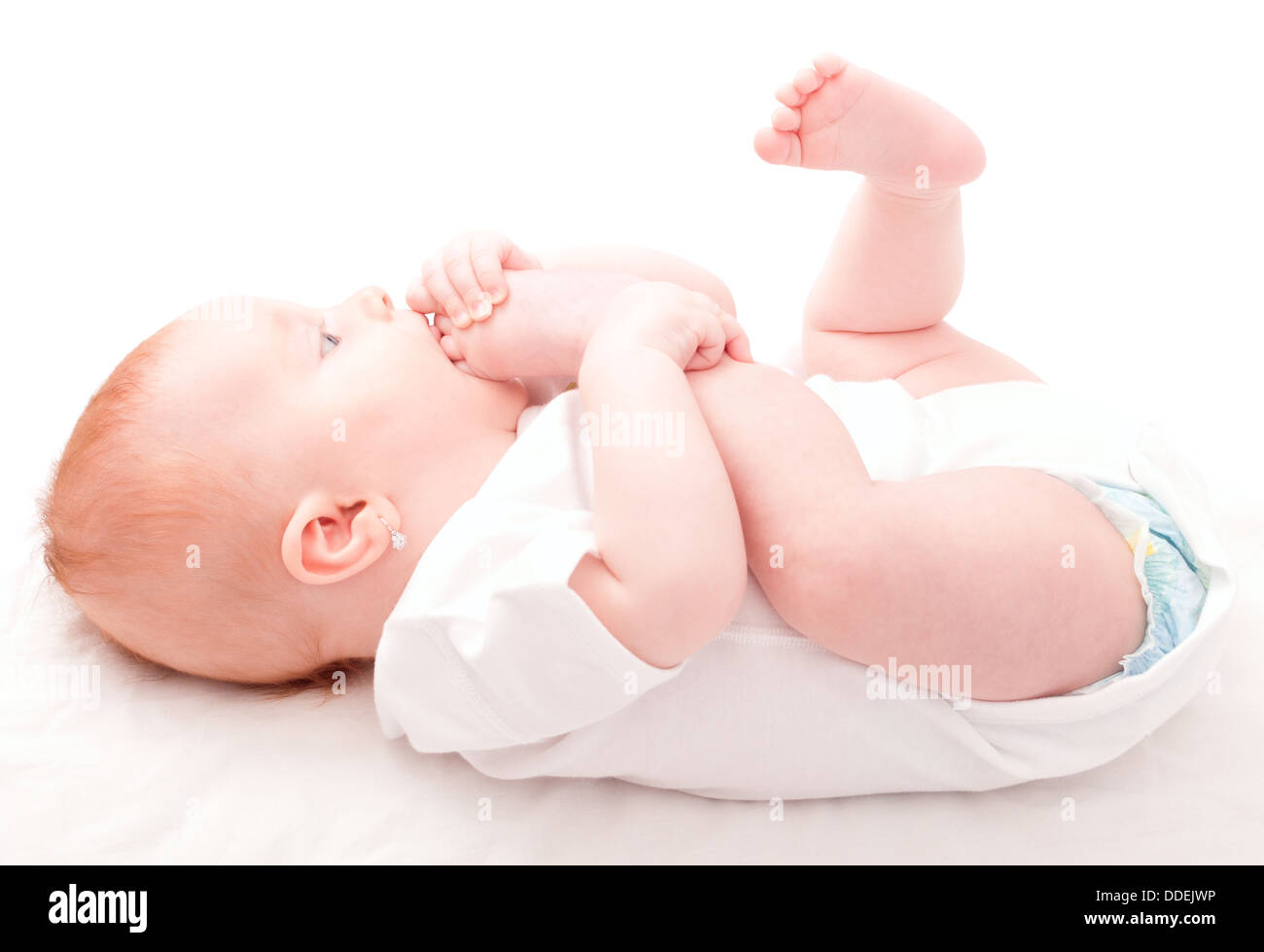 Cute Baby Girl saugen ihre Zehen auf weißem Hintergrund Stockfoto