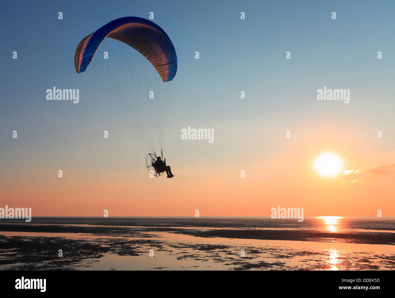 Mann in ein powered Paraglider über Heacham Buche mit Sonnenuntergang über The Wash. Stockfoto