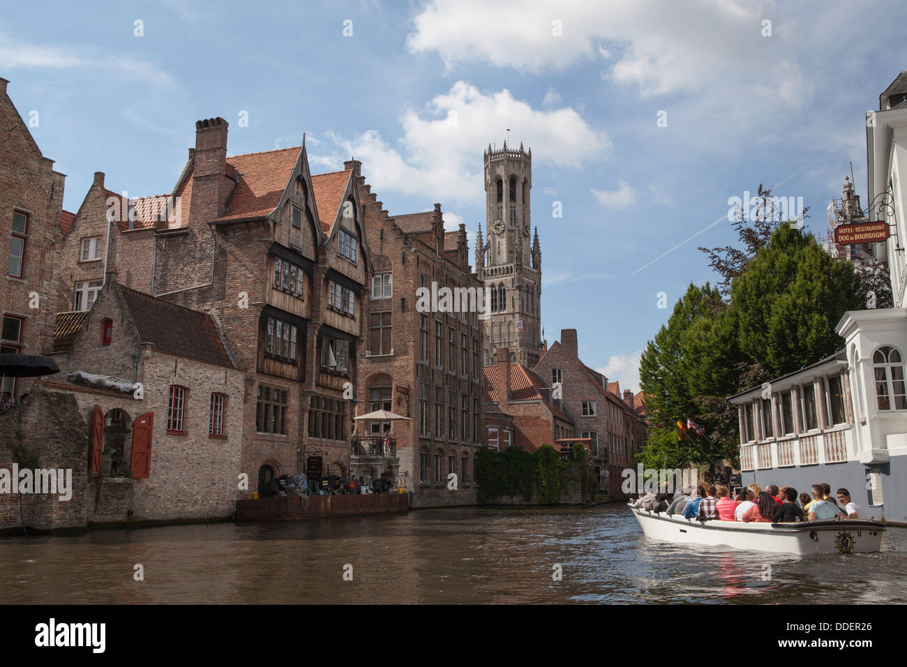 Ausflugsboot in einem der Kanäle von Brügge in Belgien mit dem Heiligen Blut-Basilika (Heilig Bloedbasiliek) im Hintergrund) Stockfoto