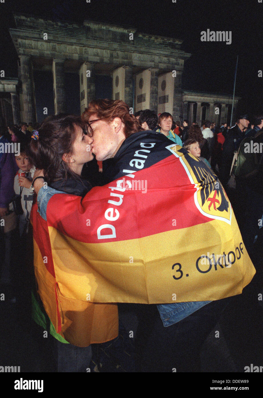 Ein junges Paar küsst vor dem Brandeburg Tor während der Feier der deutschen Einheit in Berlin, Deutschland, 2. Oktober 1990. 45 Jahre nach dem Ende des zweiten Weltkriegs, ist Deutschland in einer Nation vereint. Die innerdeutschen Grenze am 9. November 1989 eröffnete und leitete den Prozess der Wiedervereinigung. Stockfoto