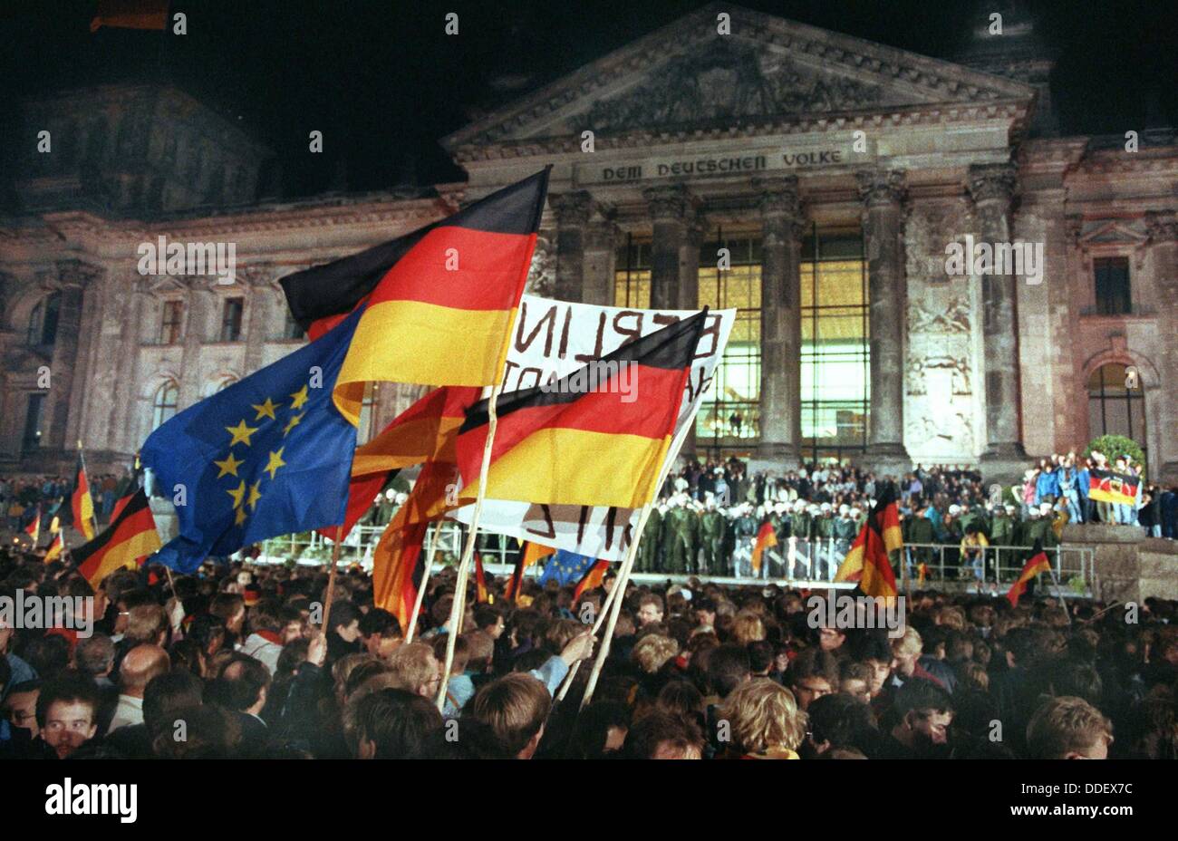 Wie hier vor dem Reichstagsgebäude, etwa 1 Million Menschen der deutschen Einheit in Berlin in der Nacht zum 3. Oktober 1990 gefeiert. Mit dem Beitritt der DDR zur Bundesrepublik Deutschland sind die deutschen schließlich in einen souveränen Staat 45 Jahre nach dem Ende des zweiten Weltkriegs wieder vereint. Stockfoto