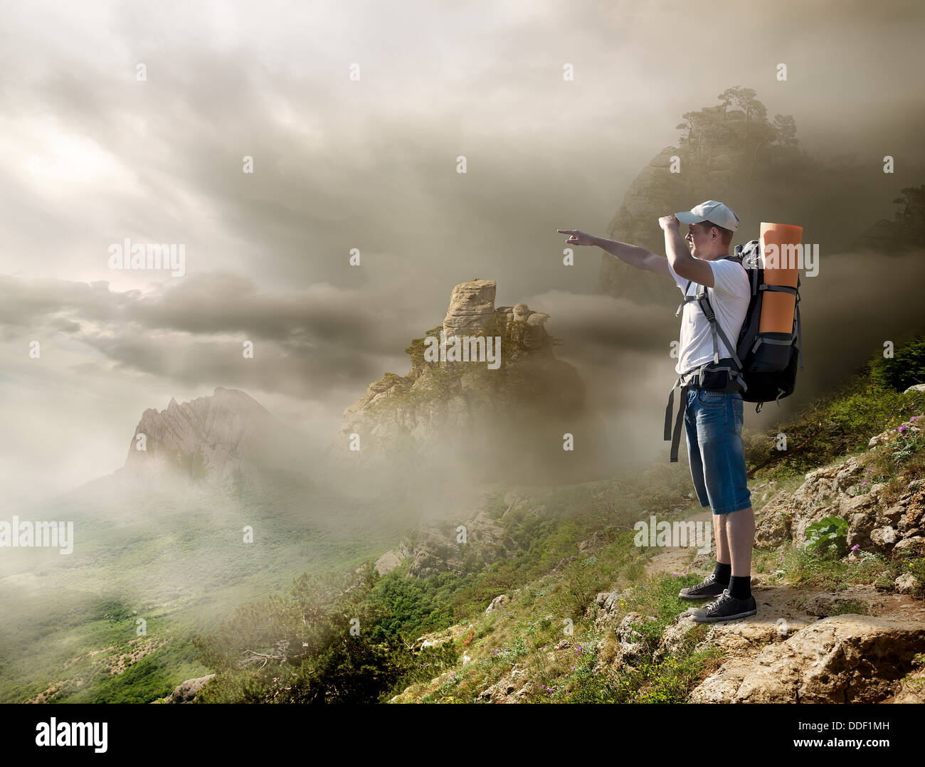 Tourist mit Rucksack genießen Talblick vom Gipfel eines Berges Stockfoto