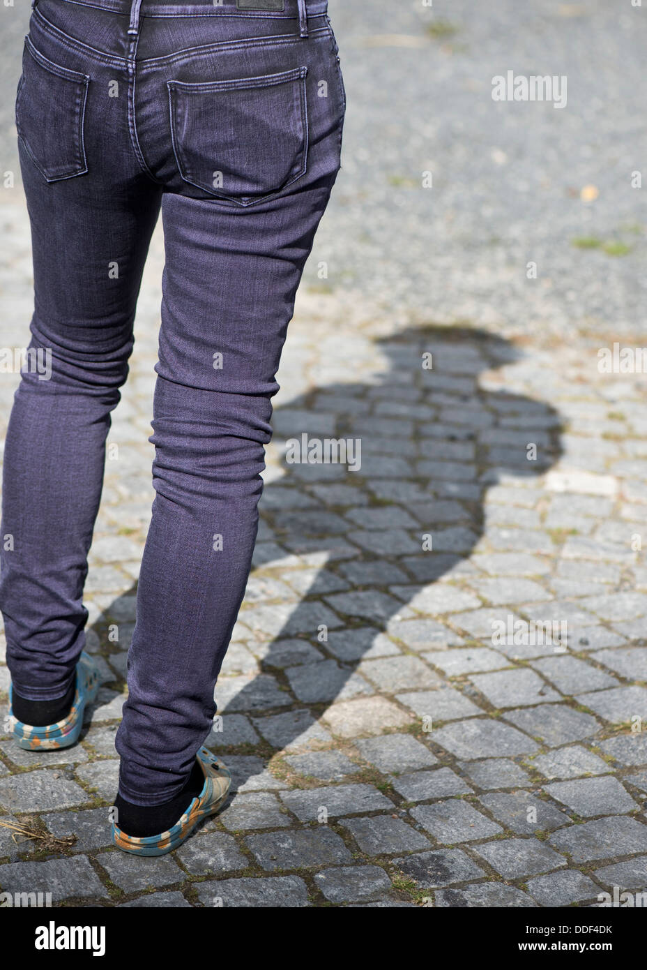 Weibliche Person, die allein mit einem Mobiltelefon in ihrer Jeans-Tasche Stockfoto