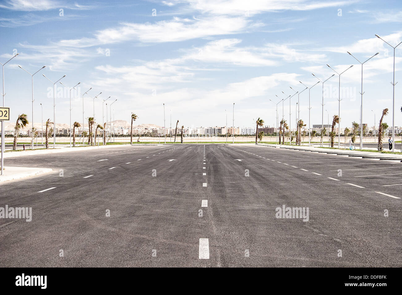 Leere Asphaltstraße mit bewölktem Himmel und Sonne Stockfoto