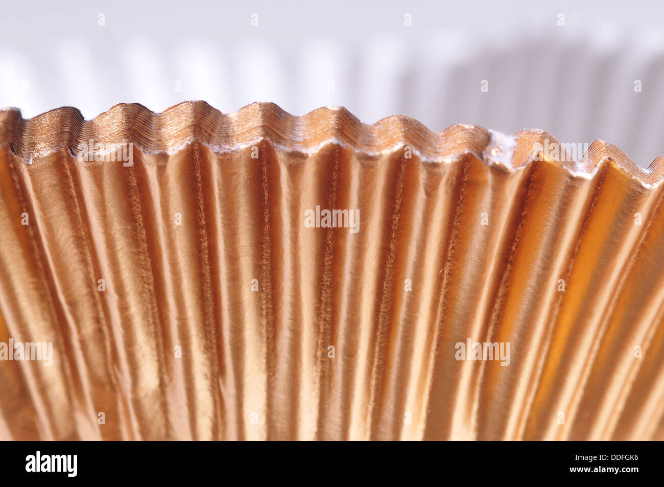 Makroaufnahme von golden Backen Tassen isoliert auf weiss Stockfoto