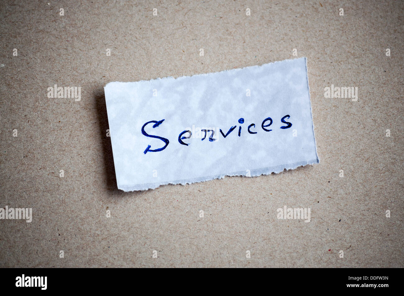 Dienstleistungen-Nachricht, geschrieben auf Papier auf Karton Hintergrund. Platz für Ihren Text. Stockfoto