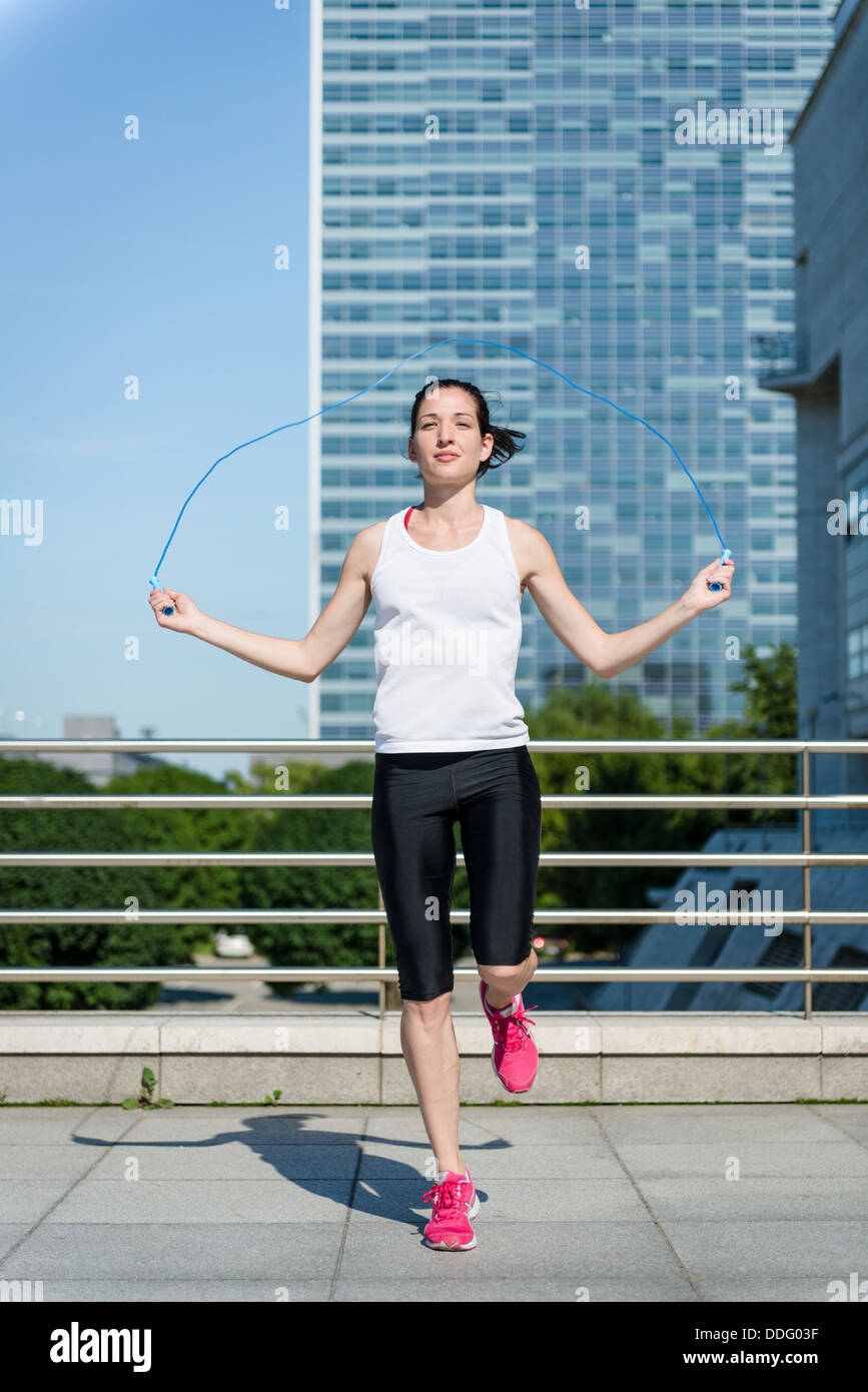 Junge Sportlerin Training mit Springseil im urbanen Umfeld Stockfoto