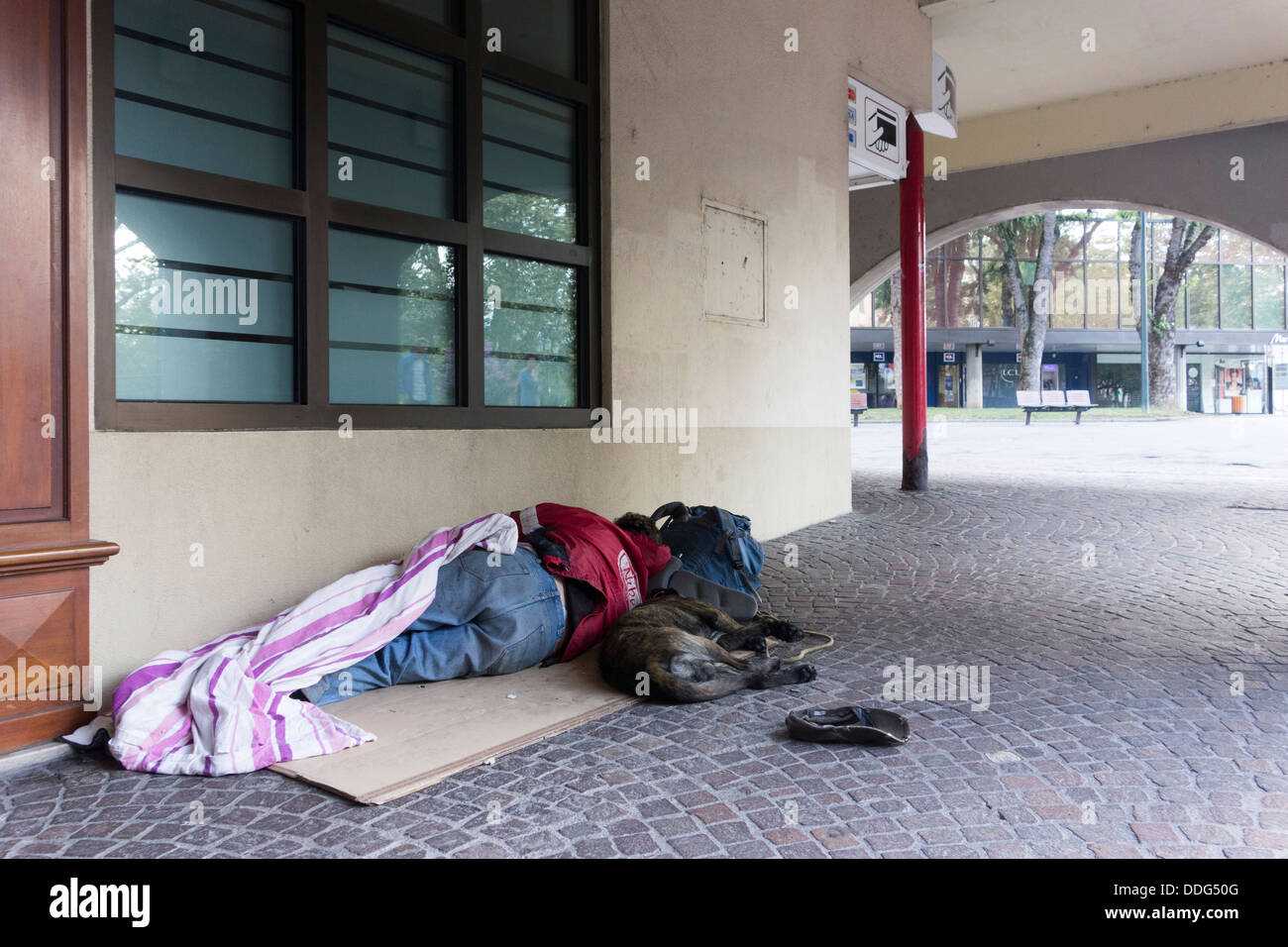 Obdachloser mit Hund schlafen auf Bürgersteig, Annecy, Frankreich Stockfoto