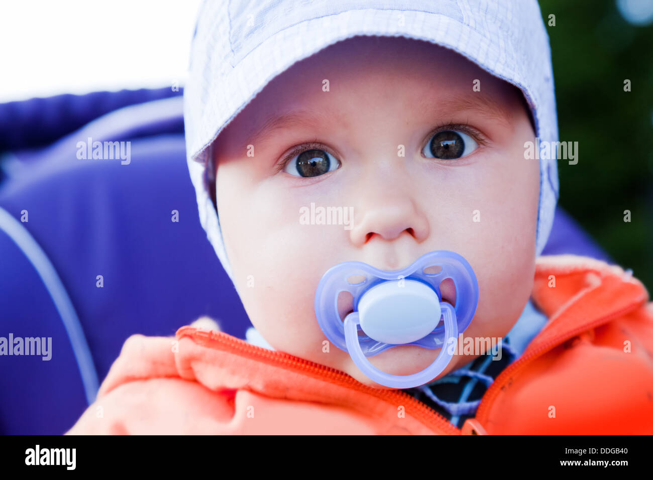 Junge baby Boy mit einem Dummy im Mund außerhalb in seinem Kinderwagen Stockfoto