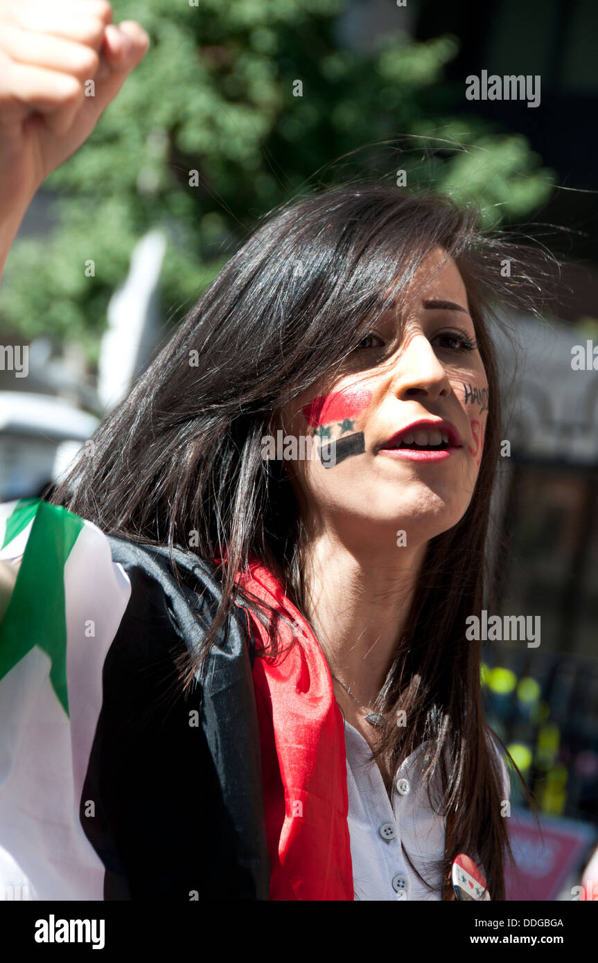 Junge syrische Frau mit Flagge gemalt auf die Wange bei Demonstration gegen die Intervention in Syrien Stockfoto