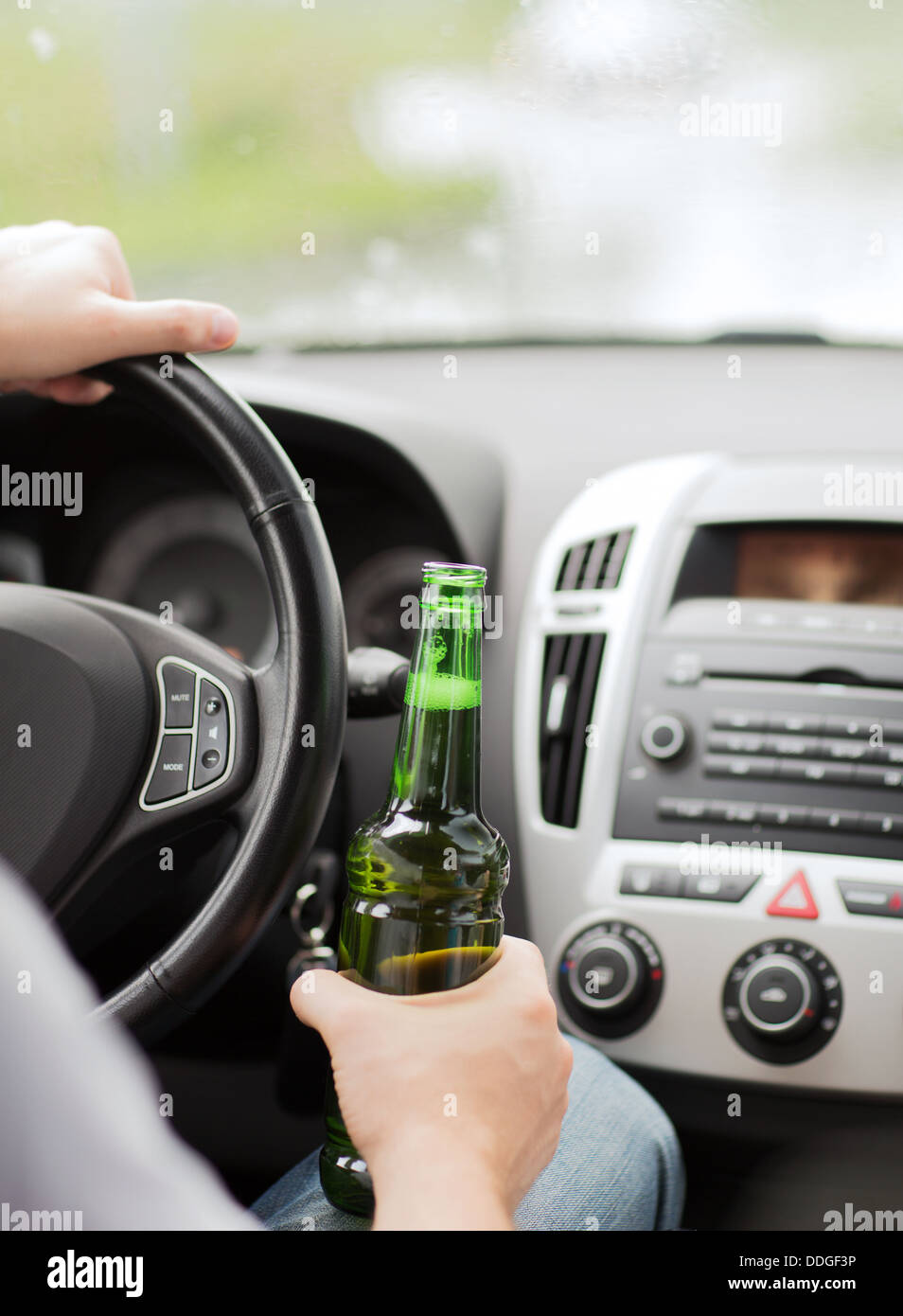 Mann, Trinken von Alkohol während der Fahrt des Autos Stockfoto