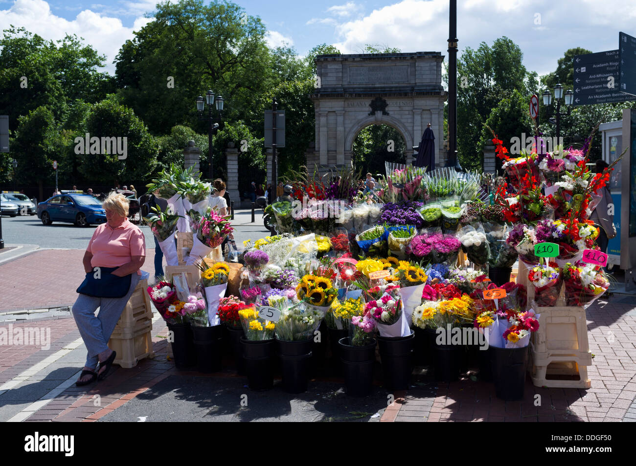 Blumenverkäuferin und ihrem Stand an der Spitze der Grafton Street, St. Stephens Green hinter, Dublin, Irland Stockfoto