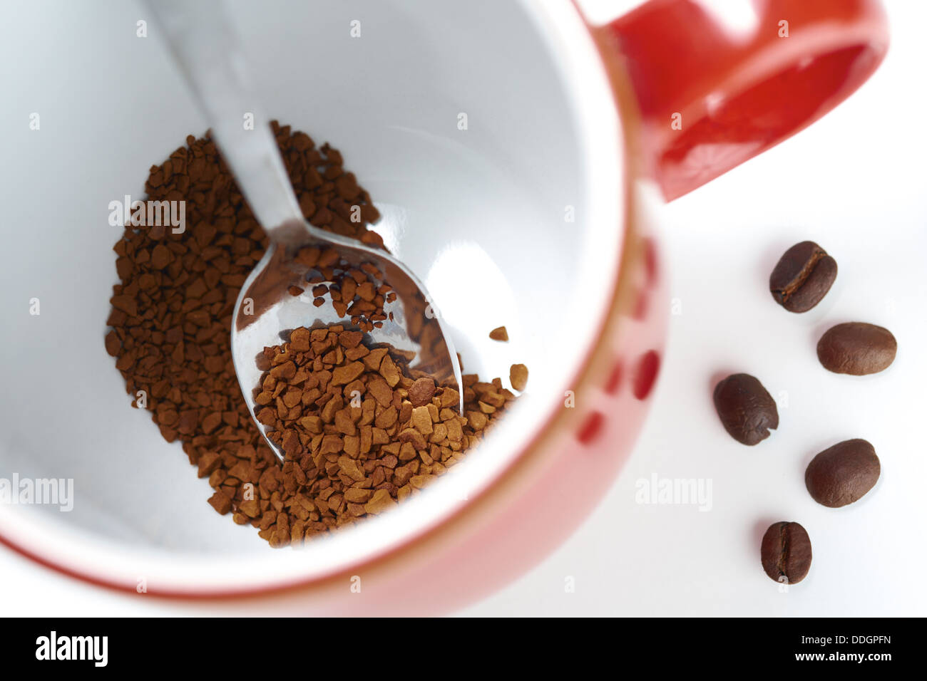 Weiße Tasse mit Kaffee Bohnen drin auf einem weißen Hintergrund isoliert. Stockfoto