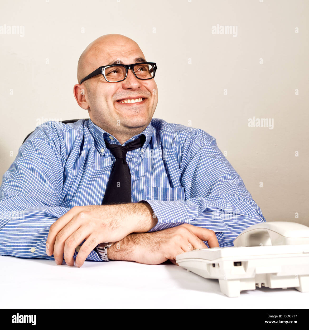 Lächelnde Geschäftsmann am Schreibtisch mit Telefon. Wheeler Händler oder Geschäft Crook. Stockfoto