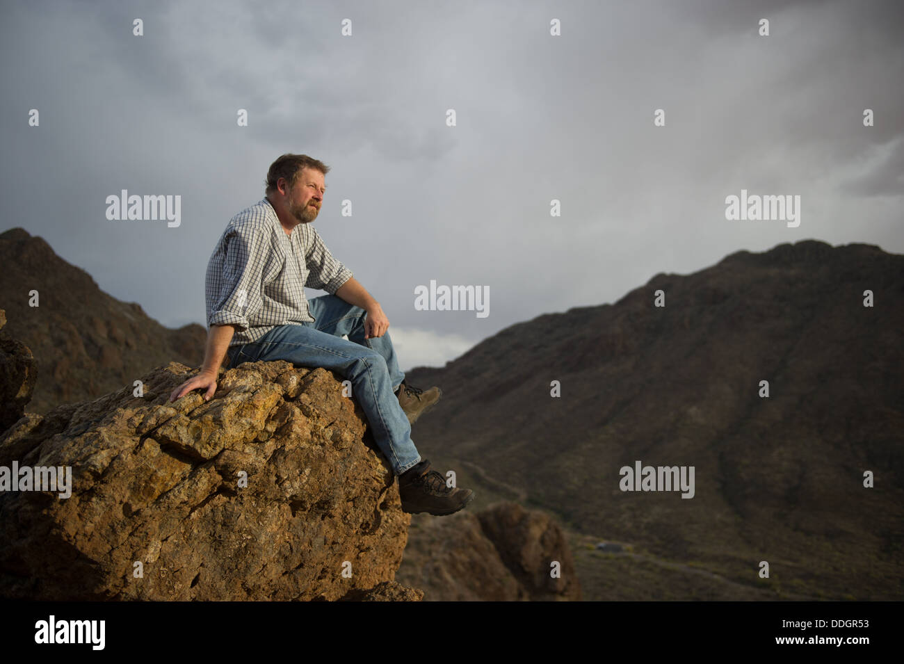 Mann sitzt auf Rock Grants Pass, Tucson Arizona Stockfoto