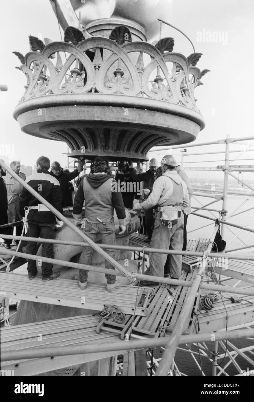 Arbeitnehmer zu senken die neu restaurierte Flamme und Geländer Montage auf Basis der Fackel der Statue of Liberty 25. November 1985 auf Liberty Island, NY. Die Restaurierung erfolgte zum hundertjährigen Jubiläum. Stockfoto