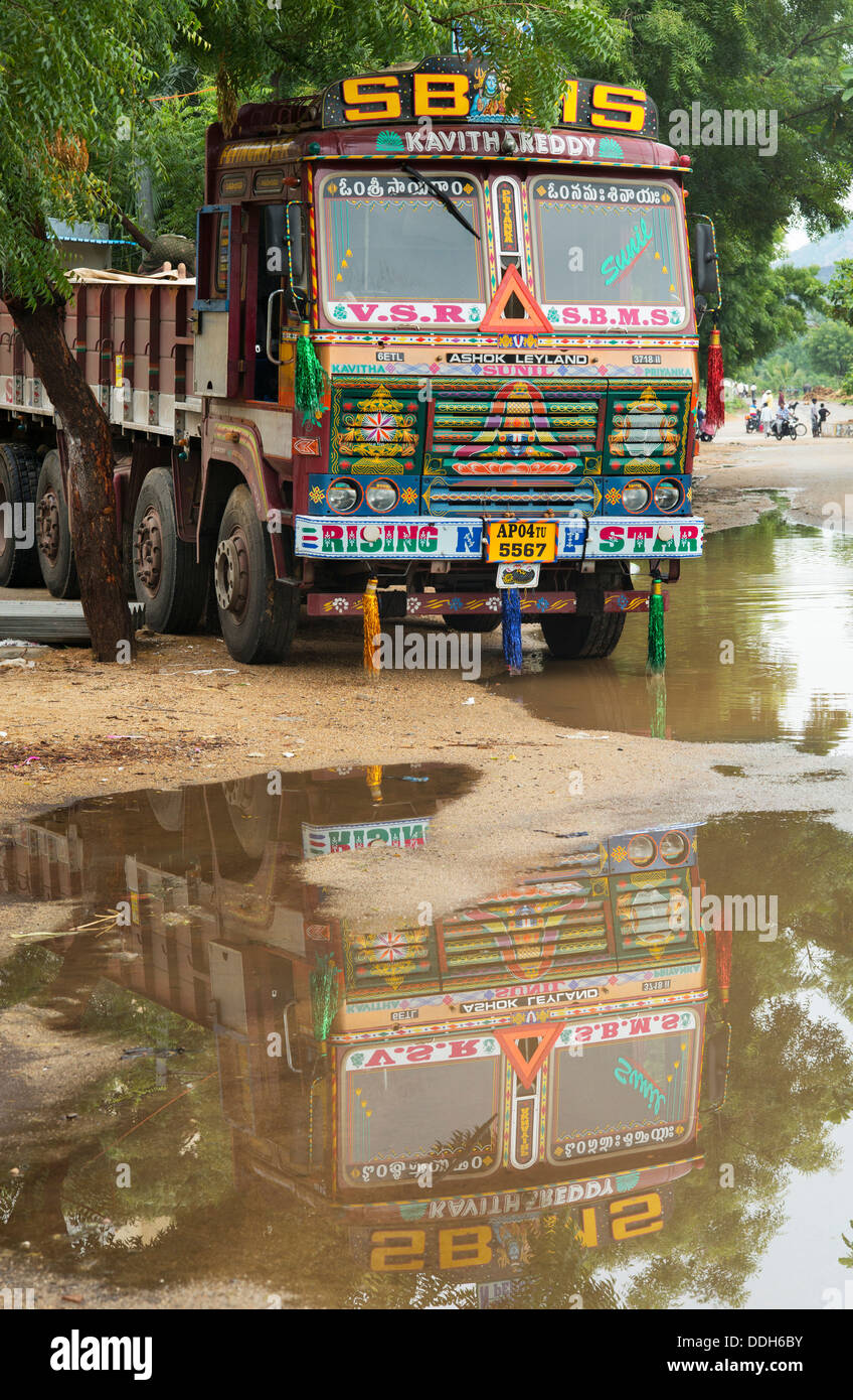 Indien Spedition LKW mit Reflektion in einer Pfütze. Puttaperthi, Andhra Pradesh, Indien Stockfoto