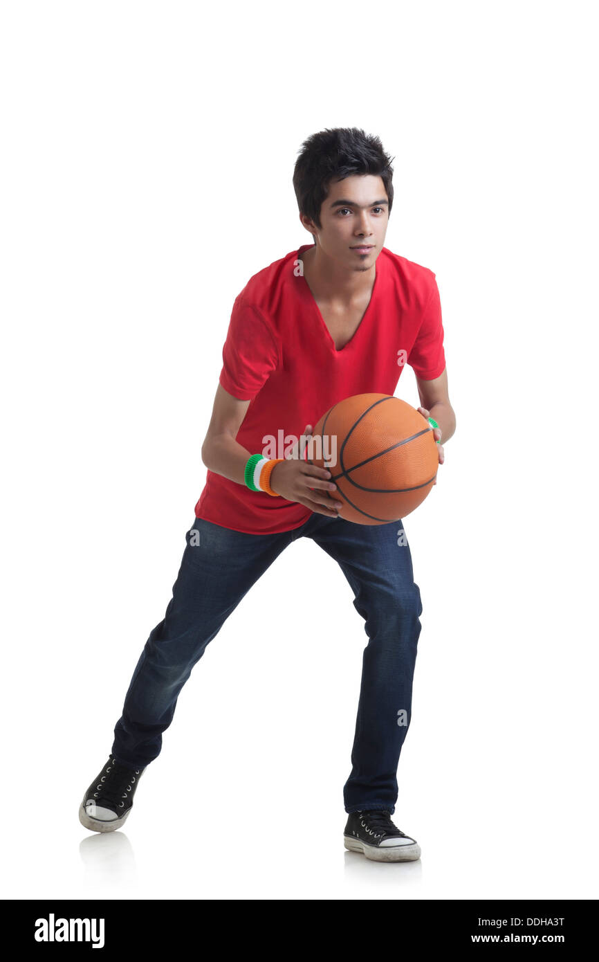 Gesamte Länge der junge bereit, Basketball über weißem Hintergrund zu werfen Stockfoto