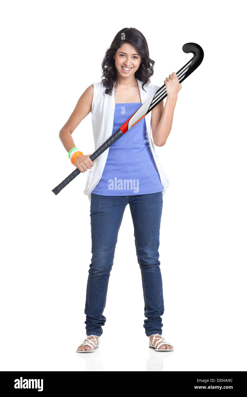 In voller Länge Portrait von junge Frau lächelnd auf weißem Hintergrund mit gedrückter Hockeyschläger Stockfoto
