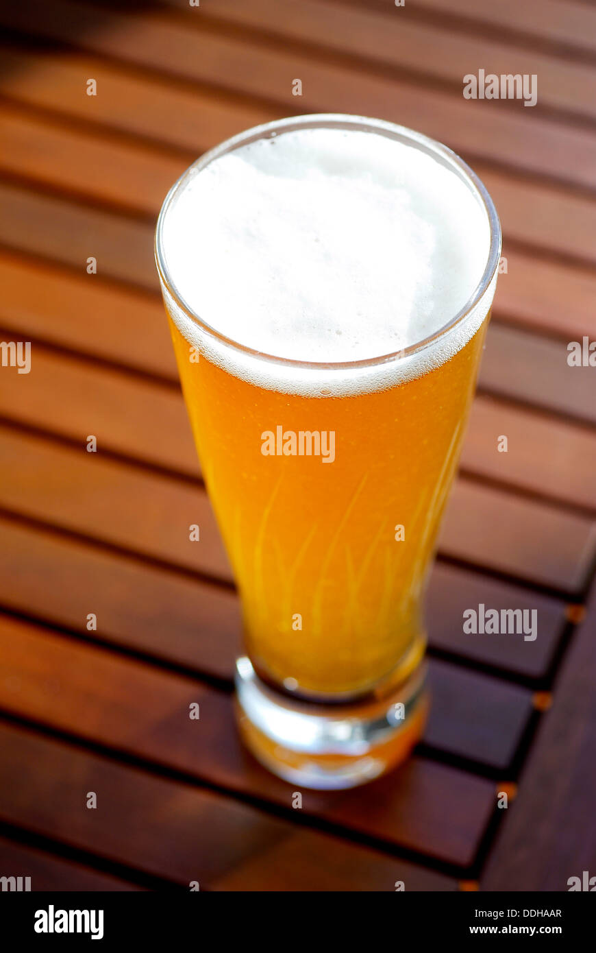 Ein Glas voll Schoner Konservierungsmittel Freibier auf einem Holzdeck-Tisch. Stockfoto