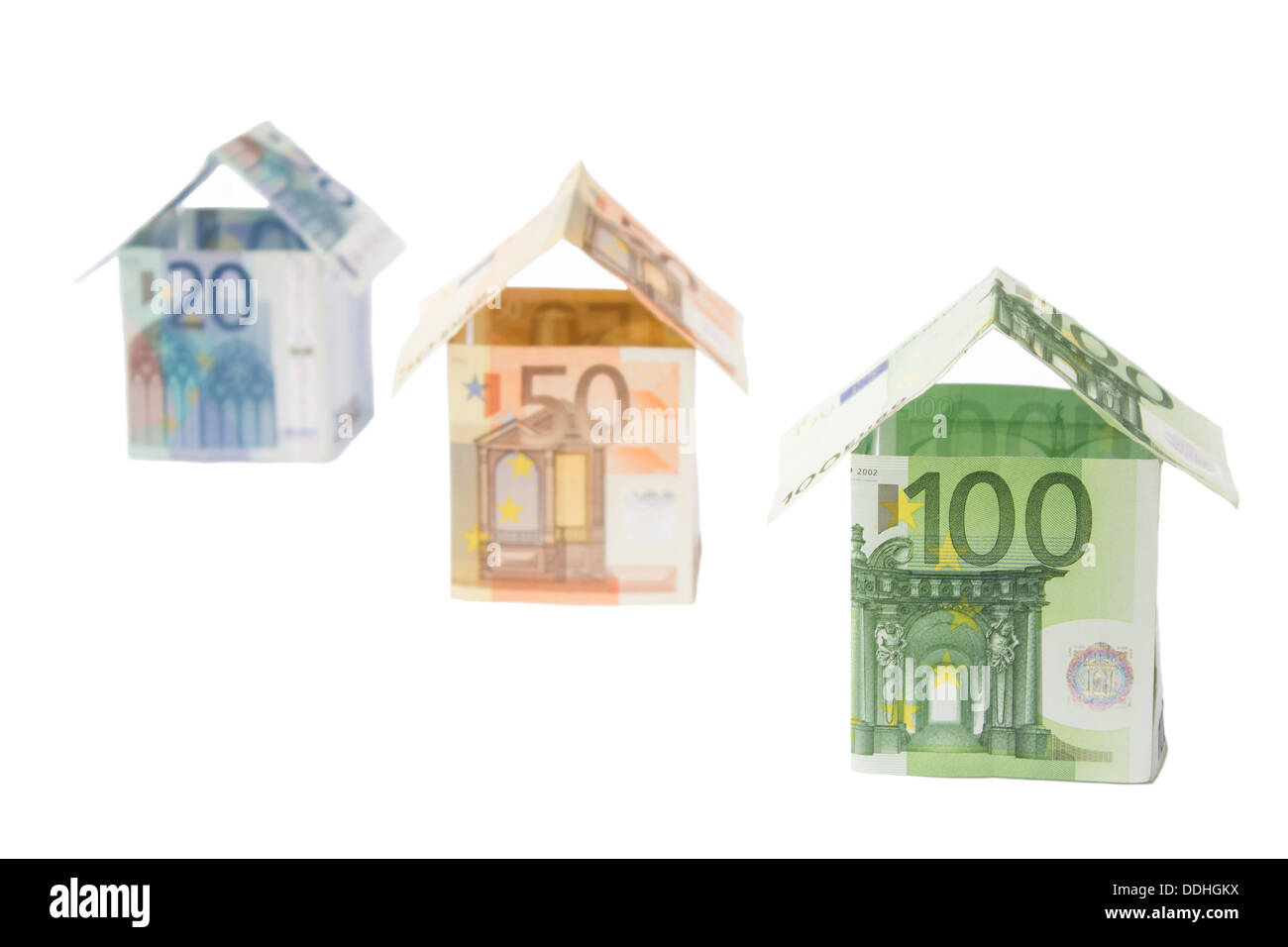 Drei Häuser aus der Euro-Banknoten stehen diagonal isoliert auf weißem Hintergrund Stockfoto