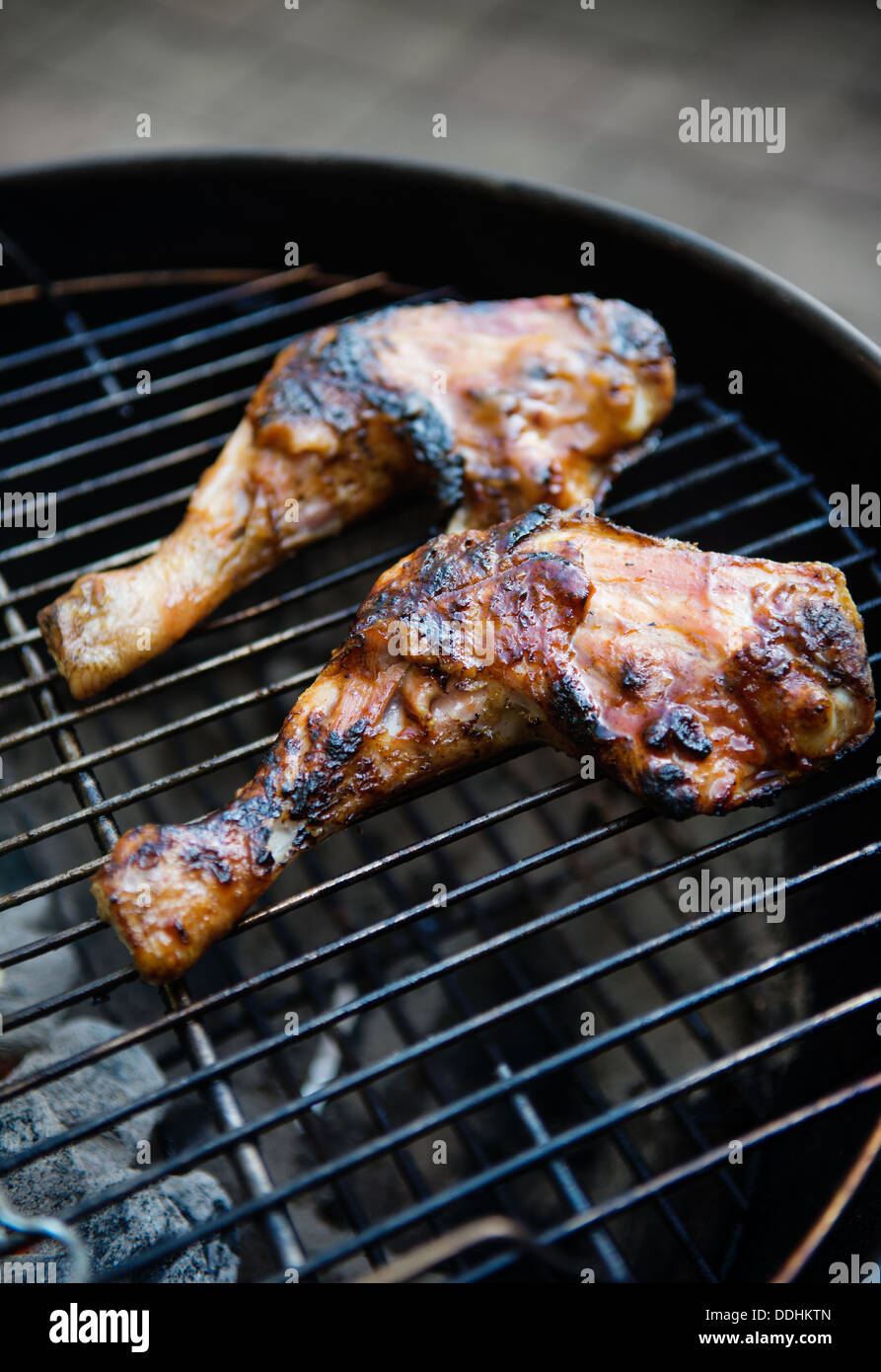 Zwei Hähnchenschenkel auf Holzkohlegrill gegart Stockfoto