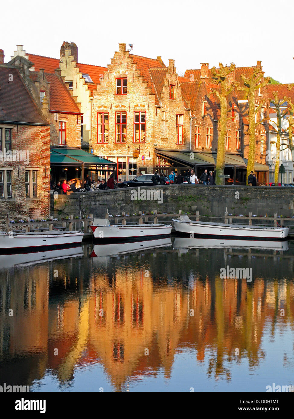 Guild Häuser mit Treppengiebeln reflektiert in einem Kanal mit Booten Stockfoto