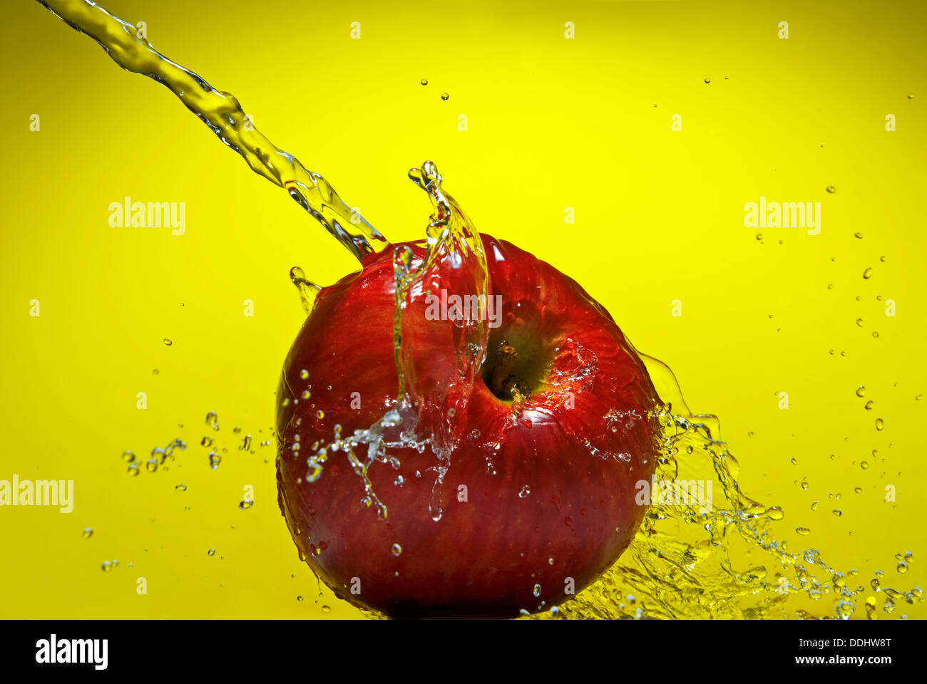 Grüner Apfel mit Spritzwasser auf blauem Hintergrund Stockfoto