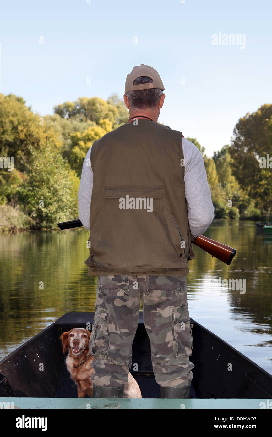 Jäger mit Hund auf Boot Stockfoto