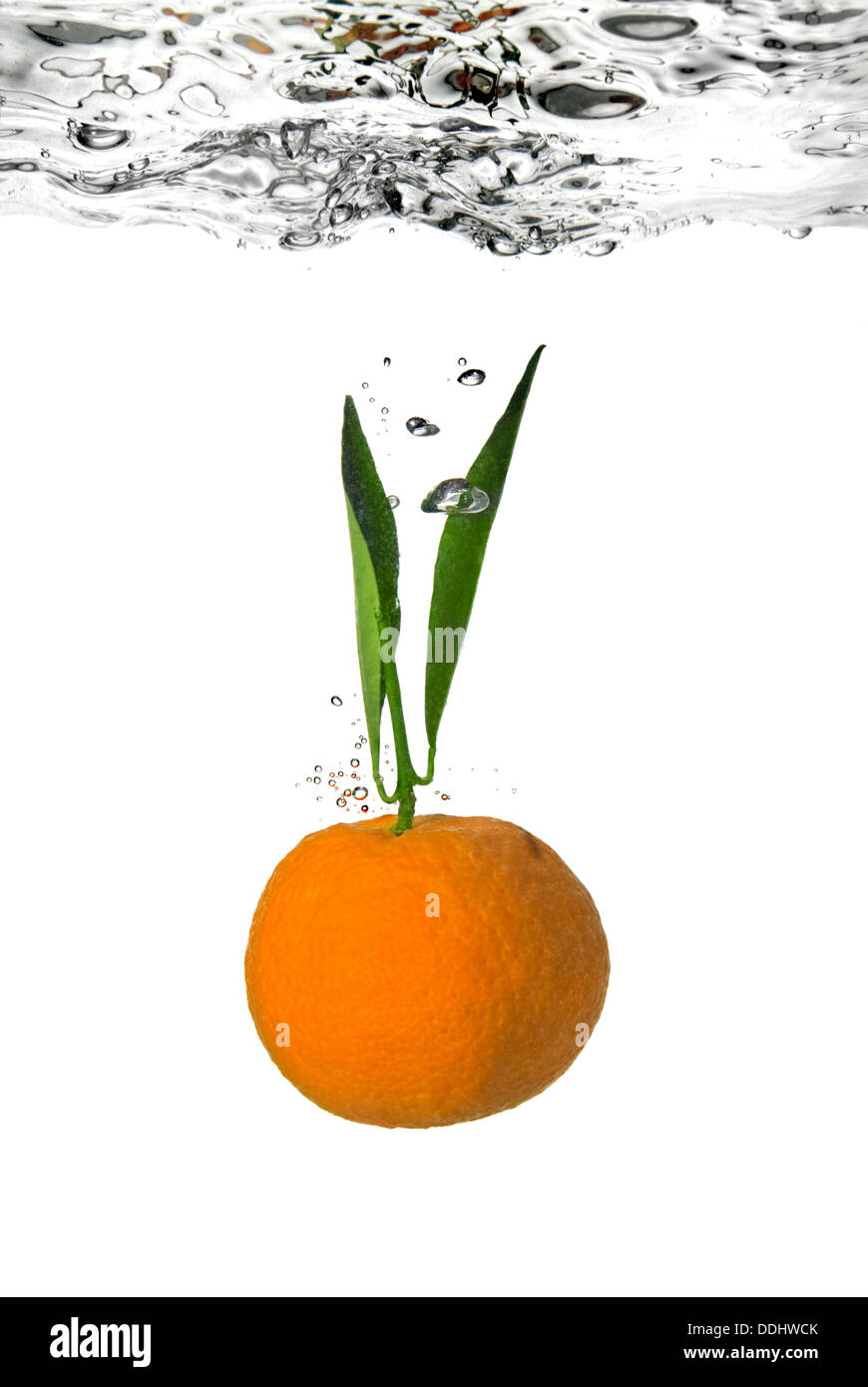 Mandarine fiel ins Wasser Blasen auf weiß Stockfoto