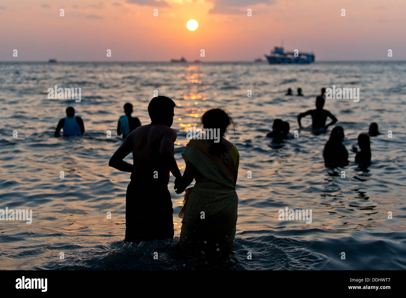 Hindu-Pilger nehmen ein heiliges Bad im Meer bei Sonnenaufgang am Ghat Agni Theertham Stockfoto